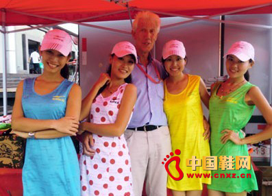 國際自行車裁判馬丁.布魯恩稱贊鴻星爾克服裝色彩時尚并與禮儀小姐合影