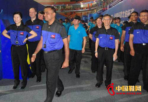 身著雙星短袖制服的國際羽聯裁判們步入賽場