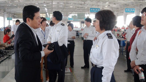 亨達股份總經理單存禮向周艷群組長介紹企業生產經營情況